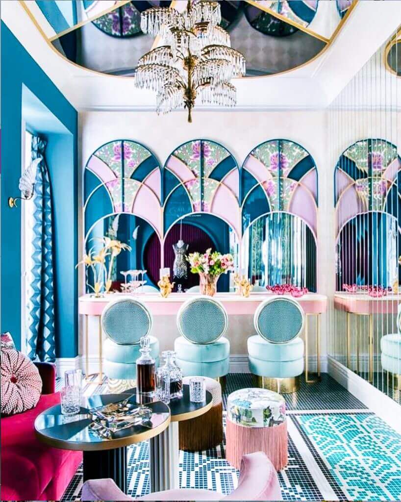 Luxurious room with Mirrors, a chandelier, gold embellishments in turquoise, blue, and pink colors.