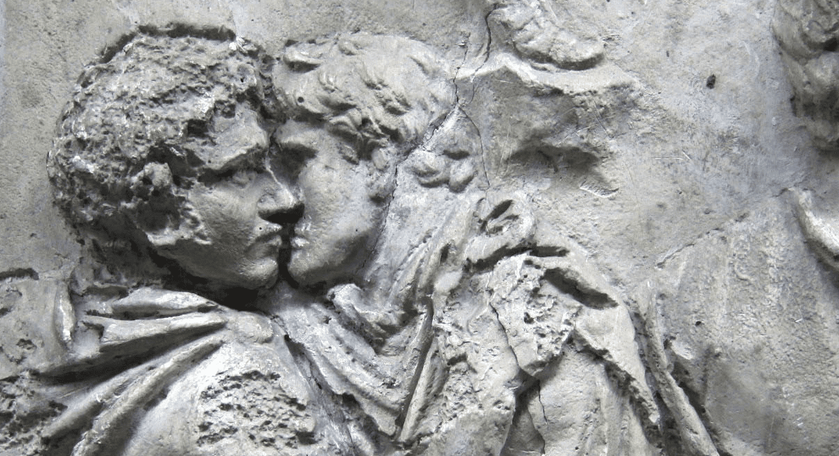 Stone relief of two Roman men kissing. 