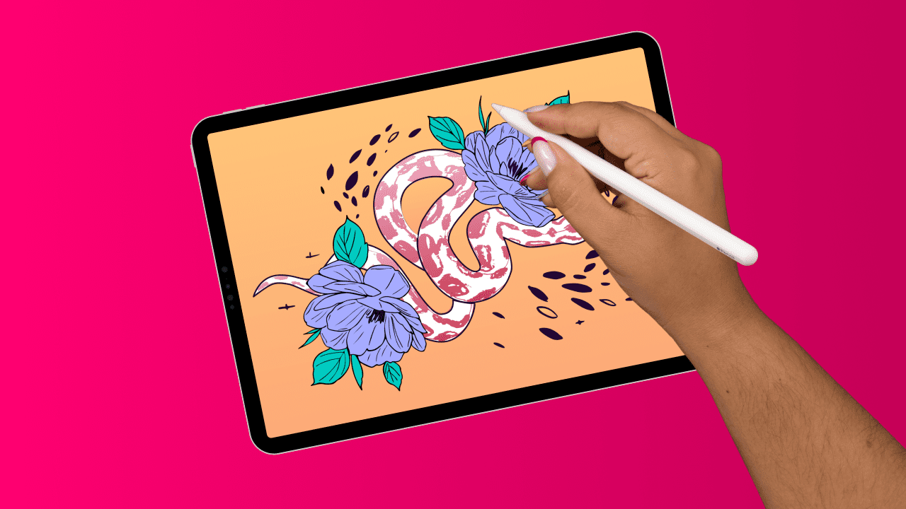 Female hand drawing a snake on an iPad on a pink background. 