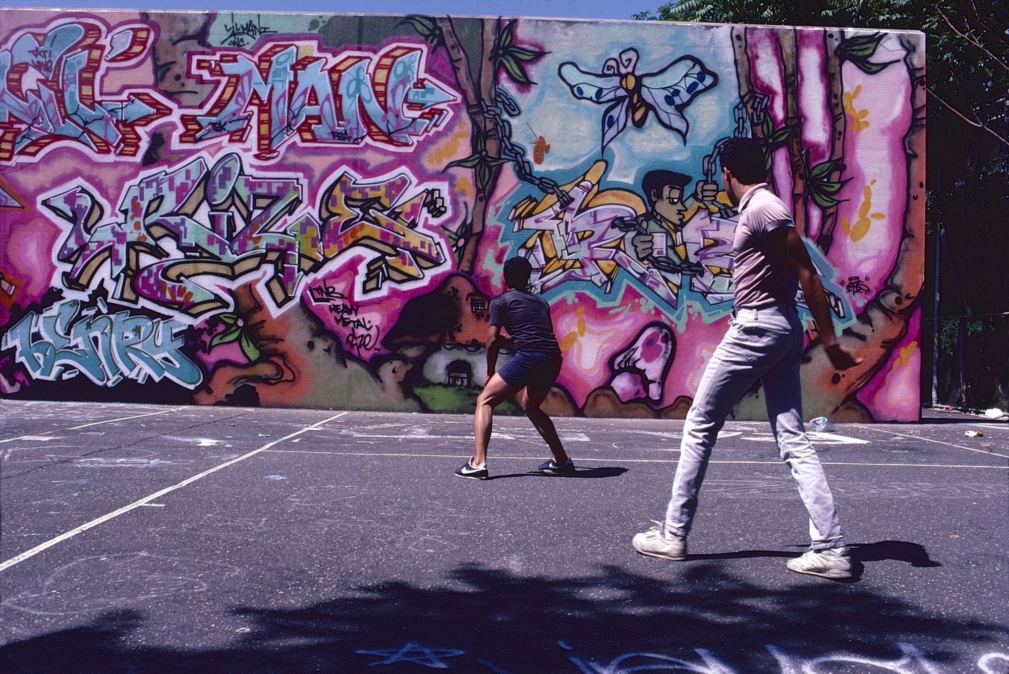 Two young men in front of a graffiti wall