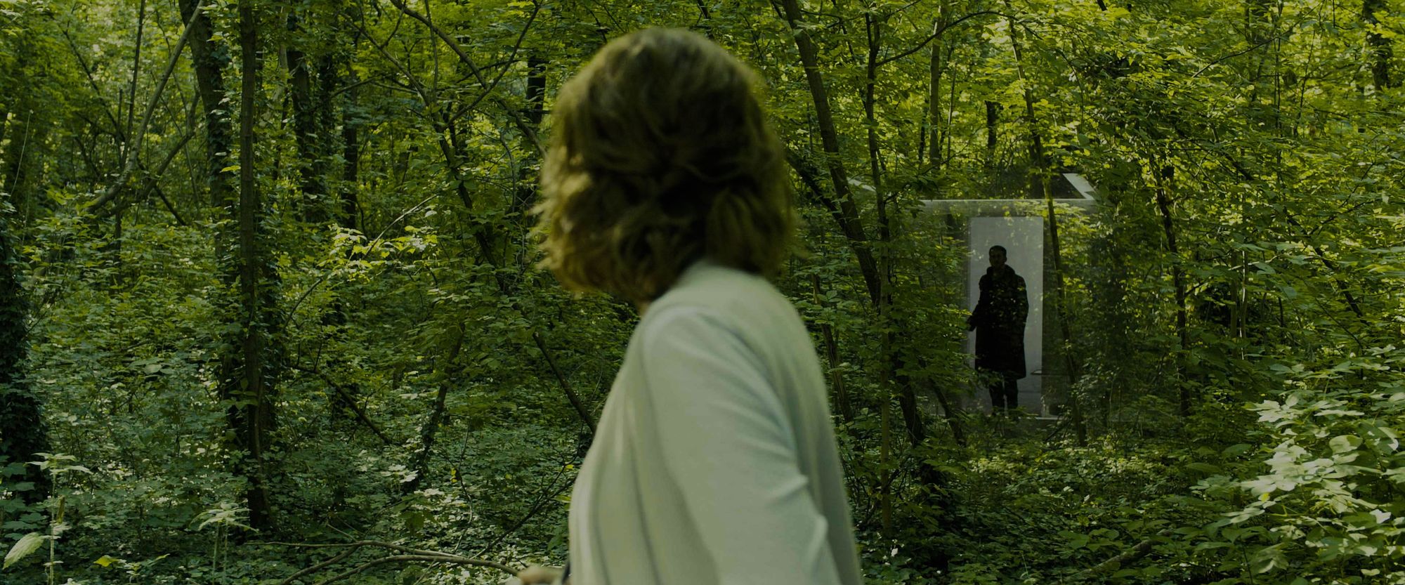 Man entering a forest via door, woman looking at him 