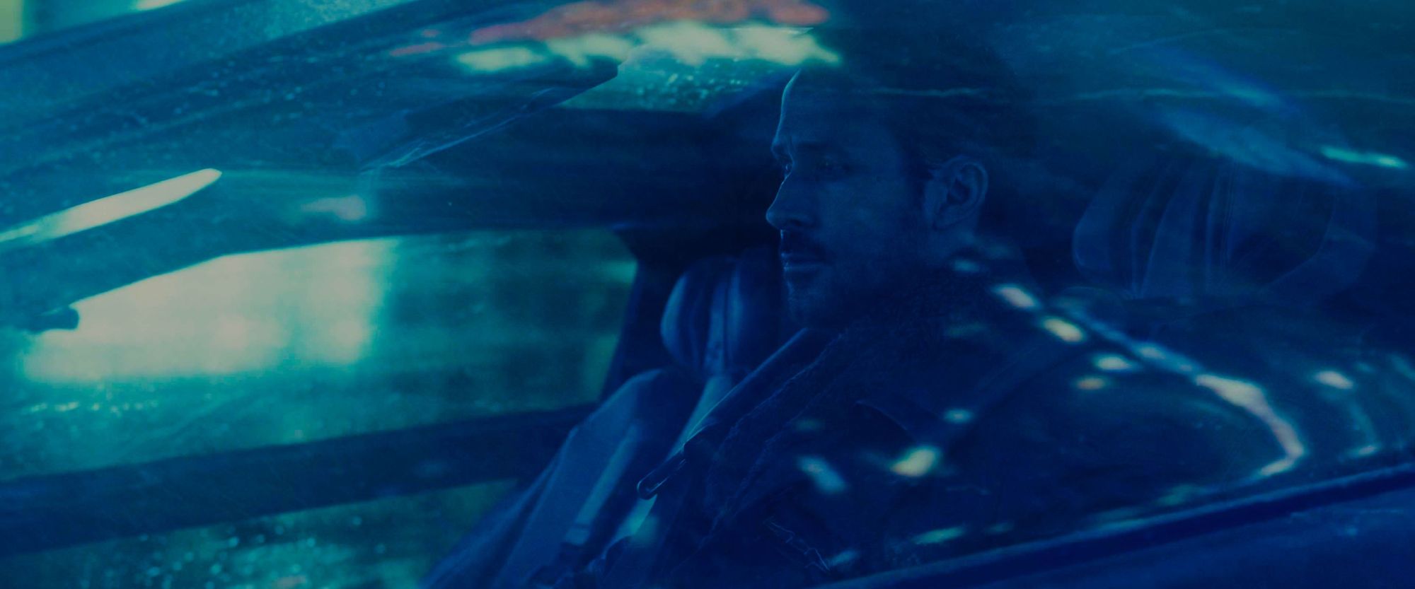 Man driving in a futuristic car in blue light
