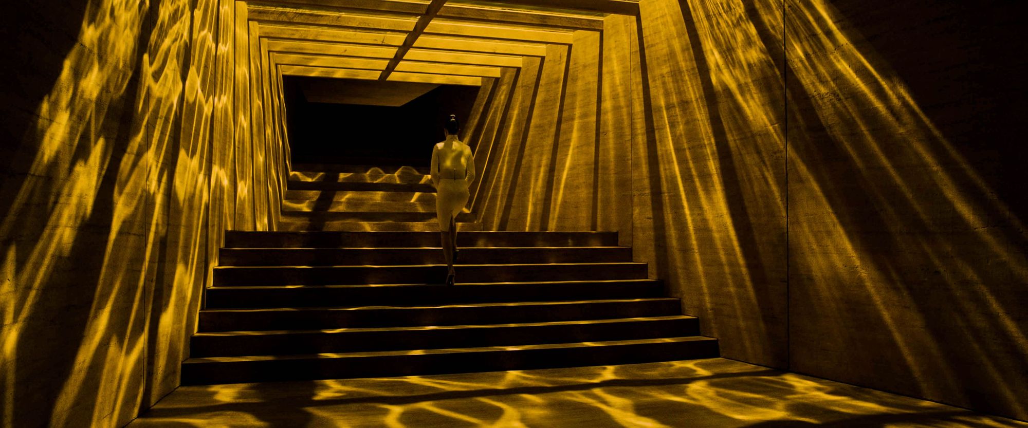 Woman walking up stairs in yellow lighting